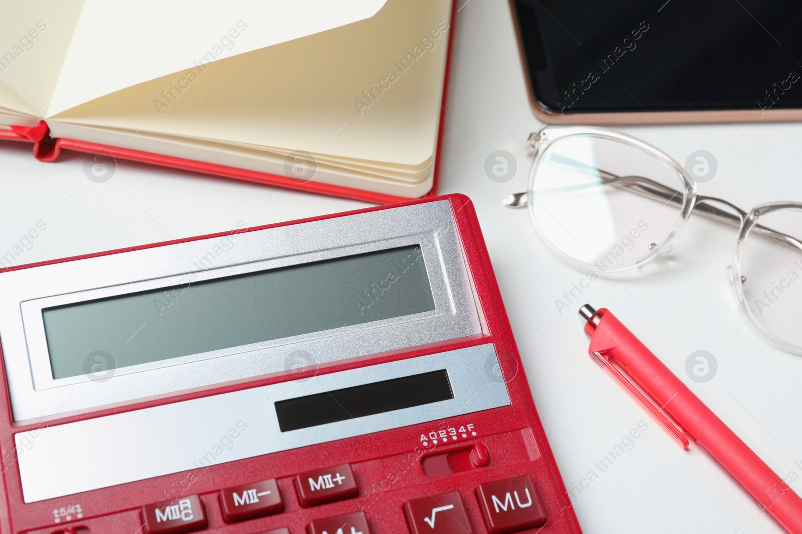 Photo of Calculator, glasses, smartphone and stationery on white table, closeup. Tax accounting