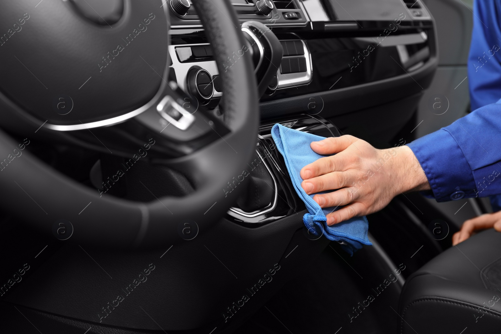 Photo of Car wash worker cleaning automobile interior, closeup