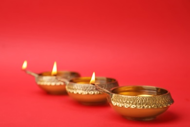 Diwali diyas or clay lamps on color background