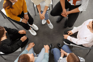 Psychotherapist working with patients in group therapy session, top view