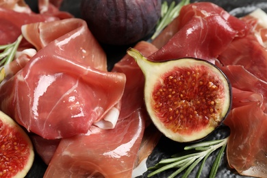 Photo of Closeup view of delicious figs and prosciutto