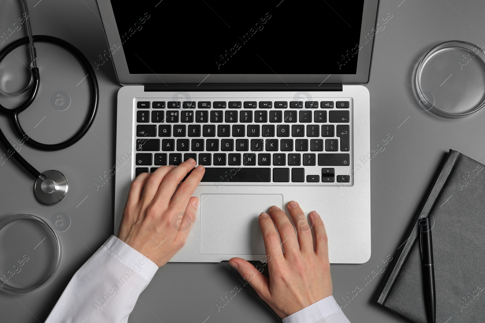 Photo of Student with modern laptop and medical stuff at table, top view