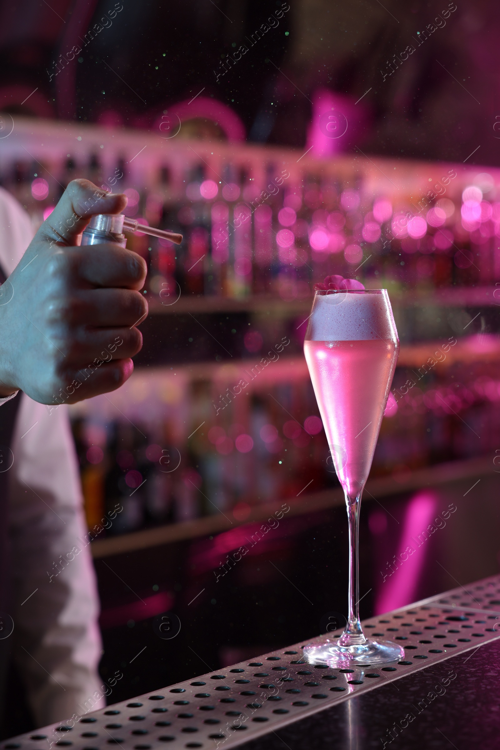 Photo of Bartender making fresh alcoholic cocktail at counter in bar, closeup