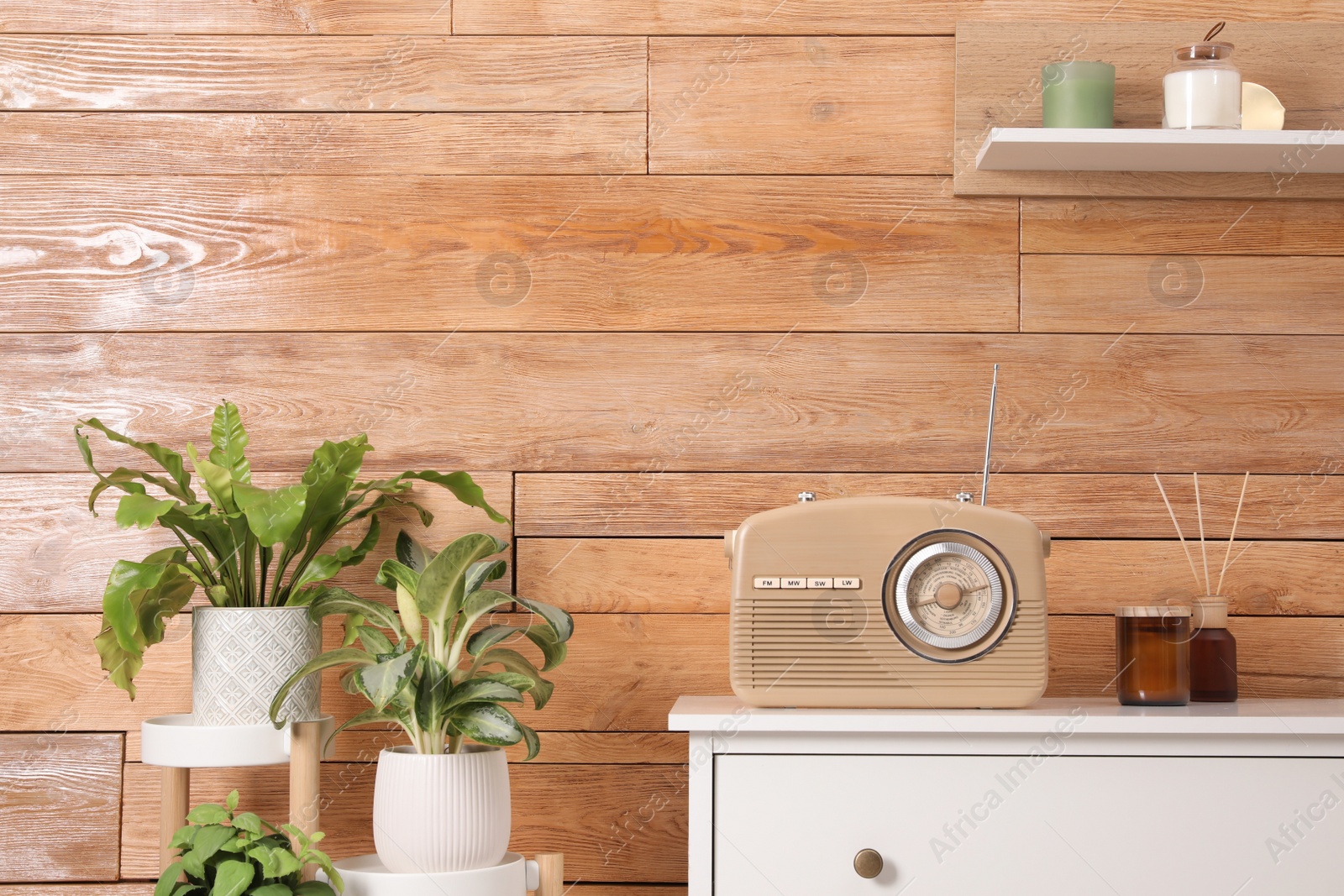 Photo of Stylish beige radio and interior elements near wooden wall indoors