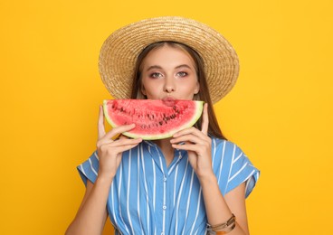 Beautiful girl with slice of watermelon on yellow background