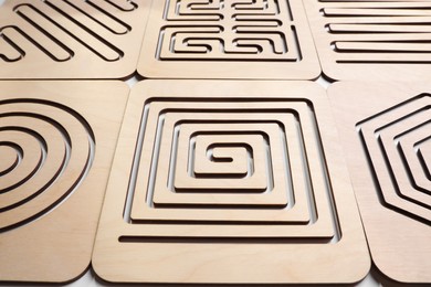Wooden finger labyrinths on white background, closeup. Montessori toy