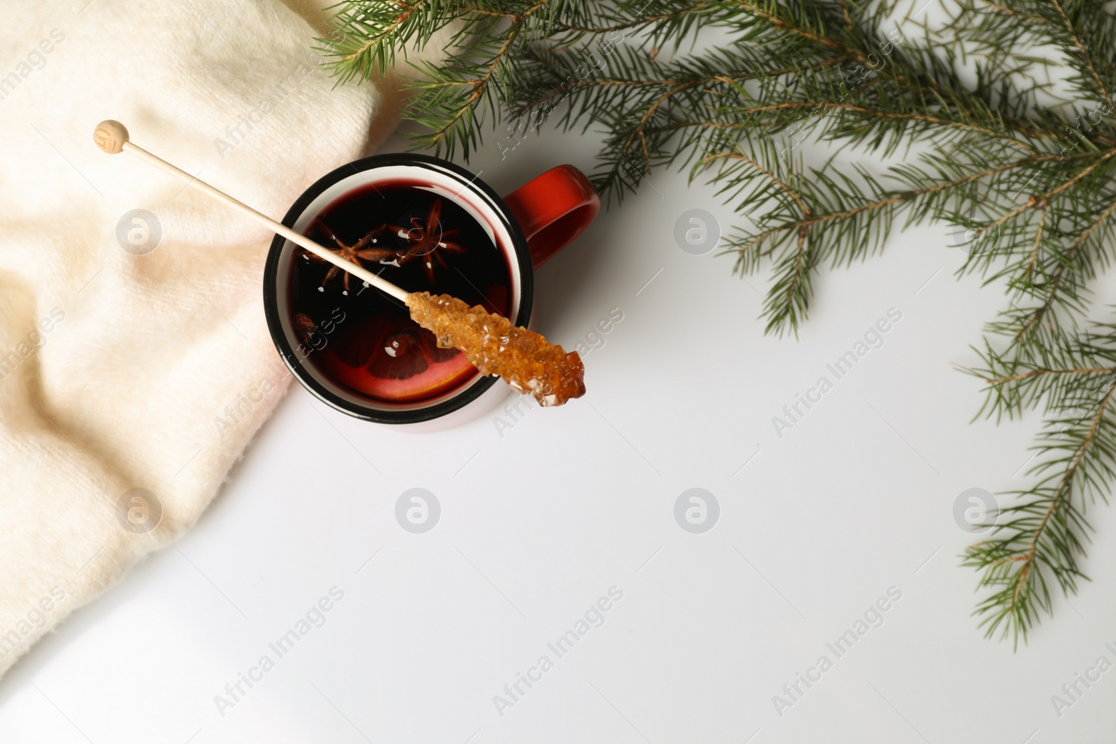 Photo of Stick with sugar crystals and cup of drink on white table, flat lay. Space for text