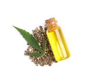 Photo of Bottle of hemp oil, leaf and seeds on white background, top view