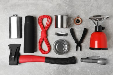 Set of traveler's equipment on grey table, flat lay