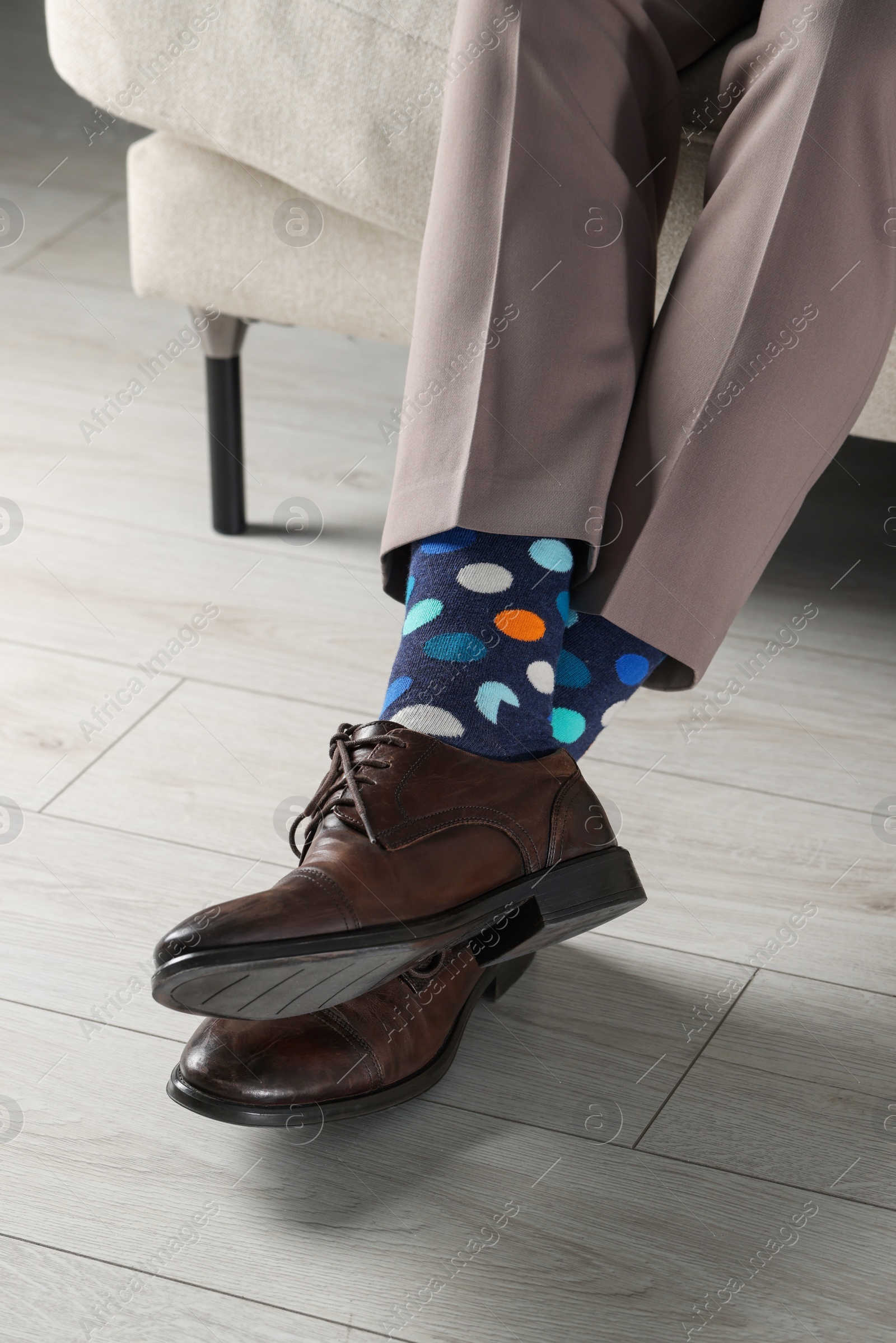 Photo of Man wearing stylish shoes and colorful socks indoors, closeup