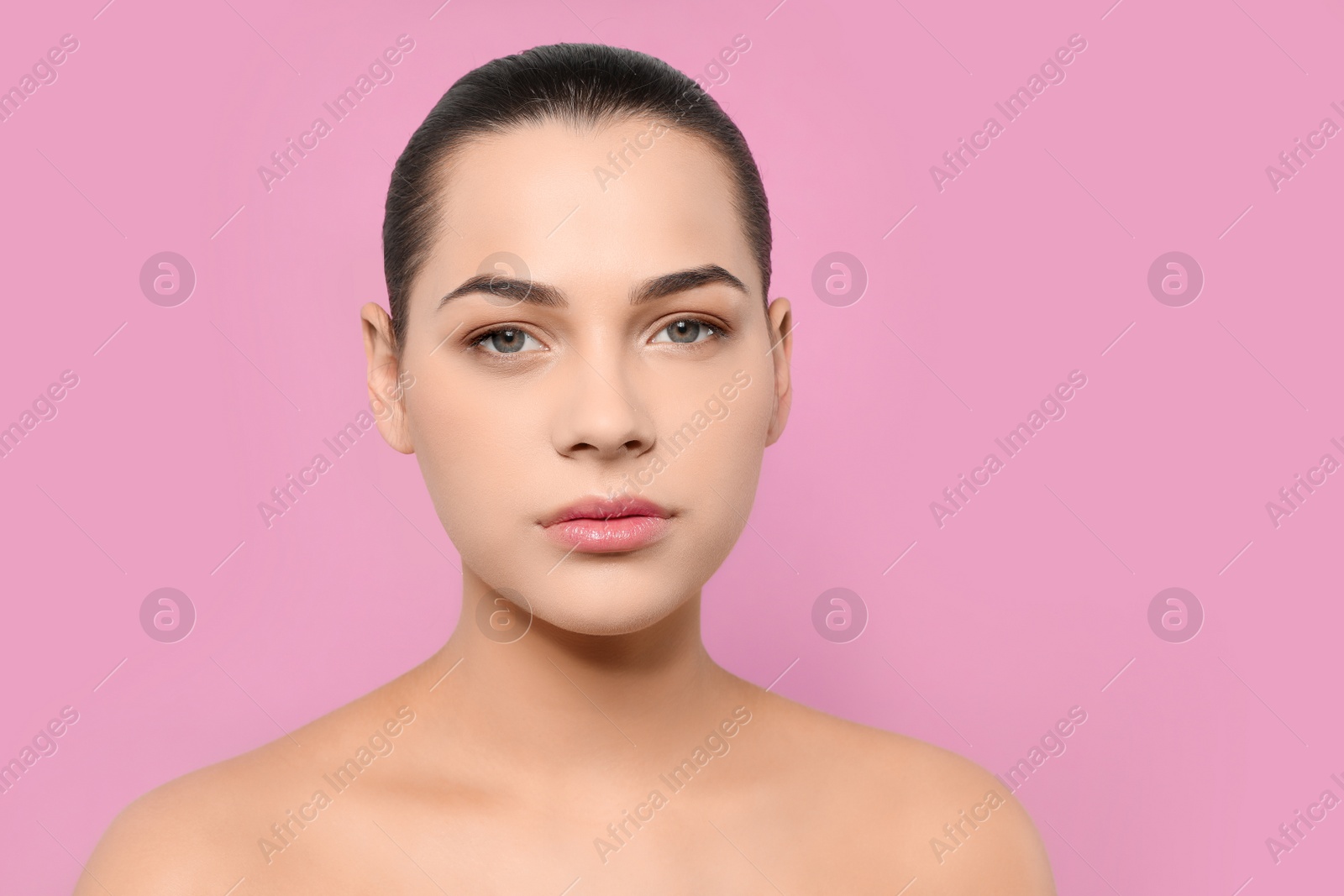 Photo of Portrait of young woman with beautiful face and natural makeup on color background