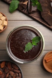 Glass of delicious hot chocolate with fresh mint on wooden table, flat lay