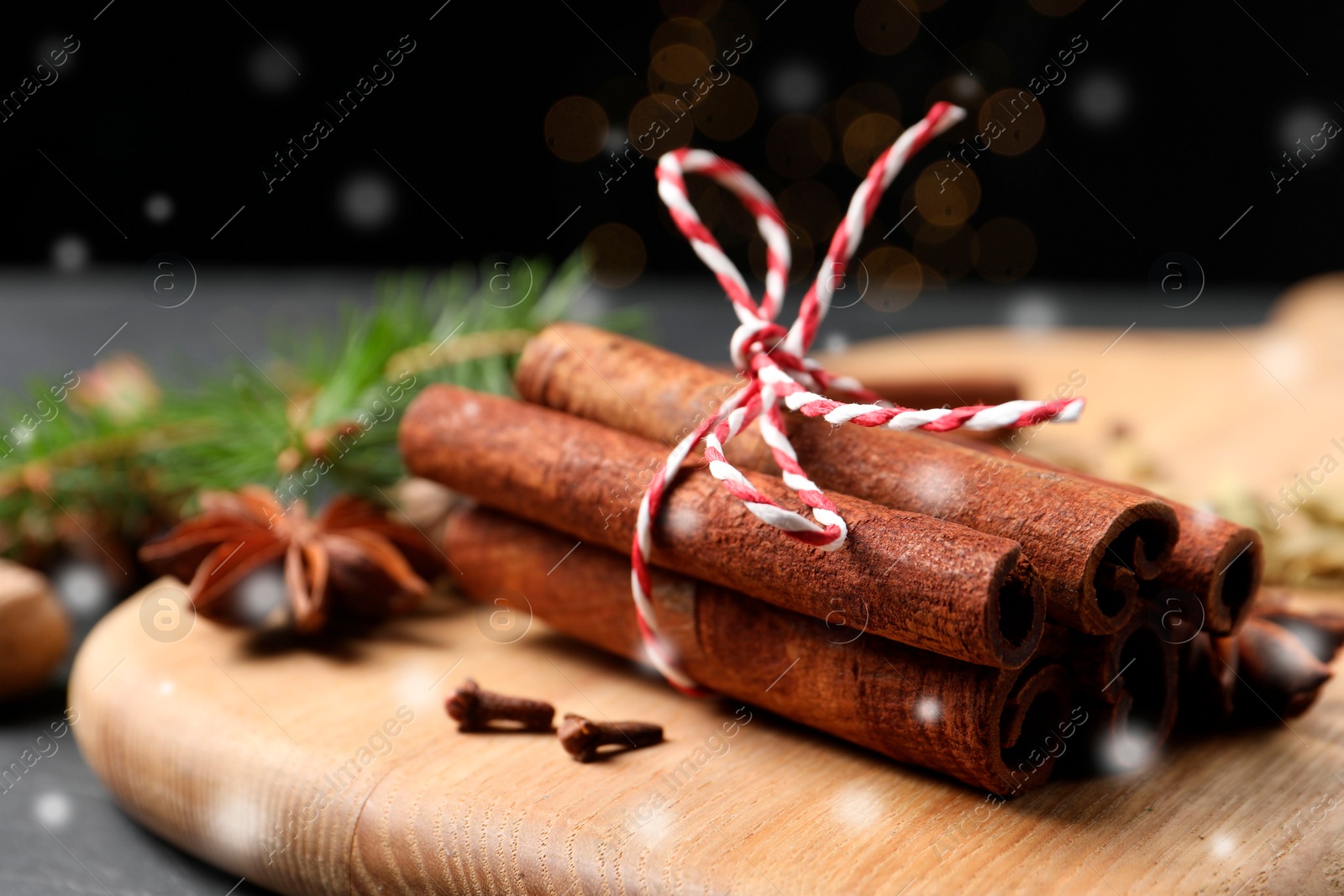 Image of Different spices and fir tree branches on dark table, closeup. Cinnamon, anise, cardamom