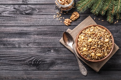 Photo of Traditional Christmas slavic dish kutia served on black wooden table, flat lay. Space for text