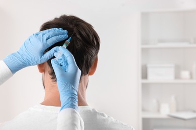 Trichologist giving injection to patient in clinic, closeup