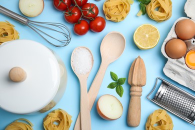 Photo of Flat lay composition with cooking utensils and fresh ingredients on light blue background