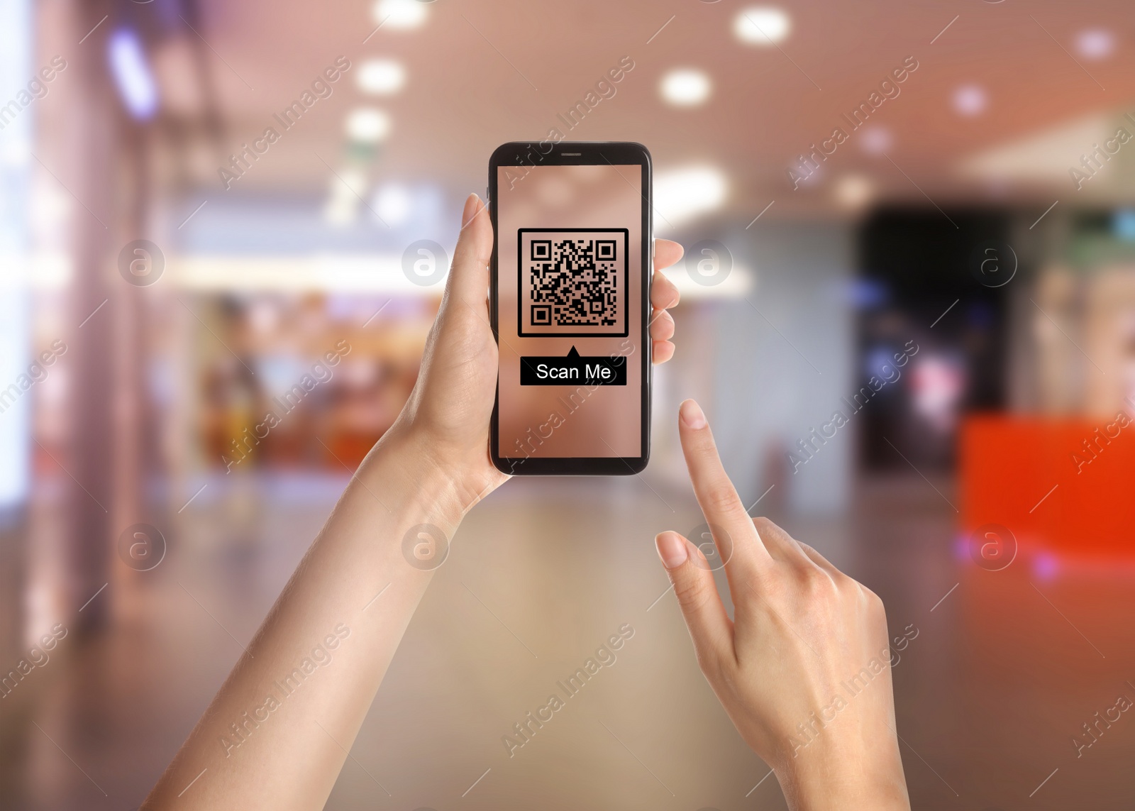 Image of Woman holding smartphone with QR code on screen in shopping mall, closeup