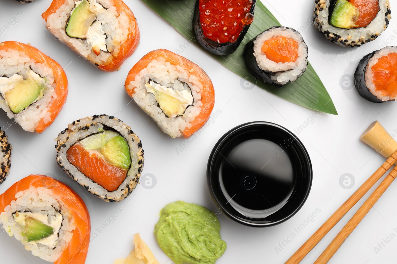 Photo of Set of delicious sushi rolls on white background, flat lay