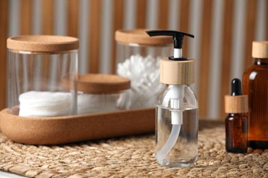 Photo of Bottle with dispenser cap and essential personal hygiene products on table indoors