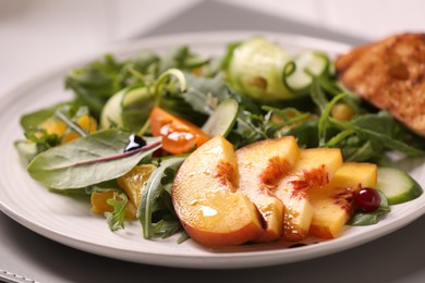 Photo of Delicious salad with peach slices on plate, closeup