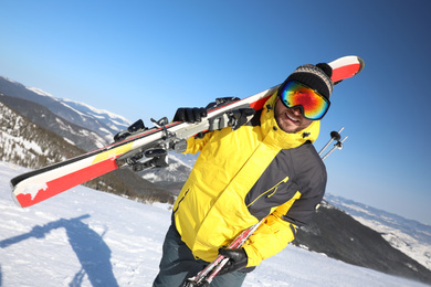 Photo of Young man with ski on hill. Winter vacation