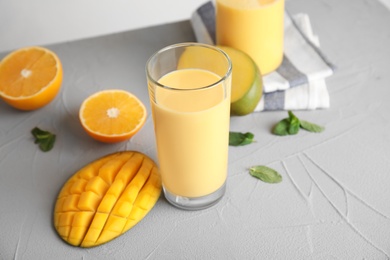 Photo of Fresh mango drink and tropical fruits on table