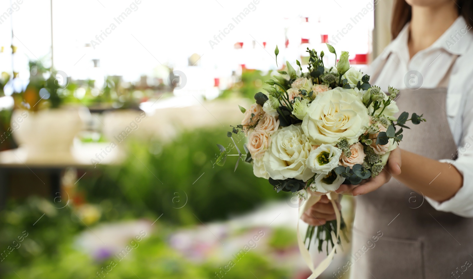 Image of Florist holding beautiful wedding bouquet in flower shop, closeup. Space for text 