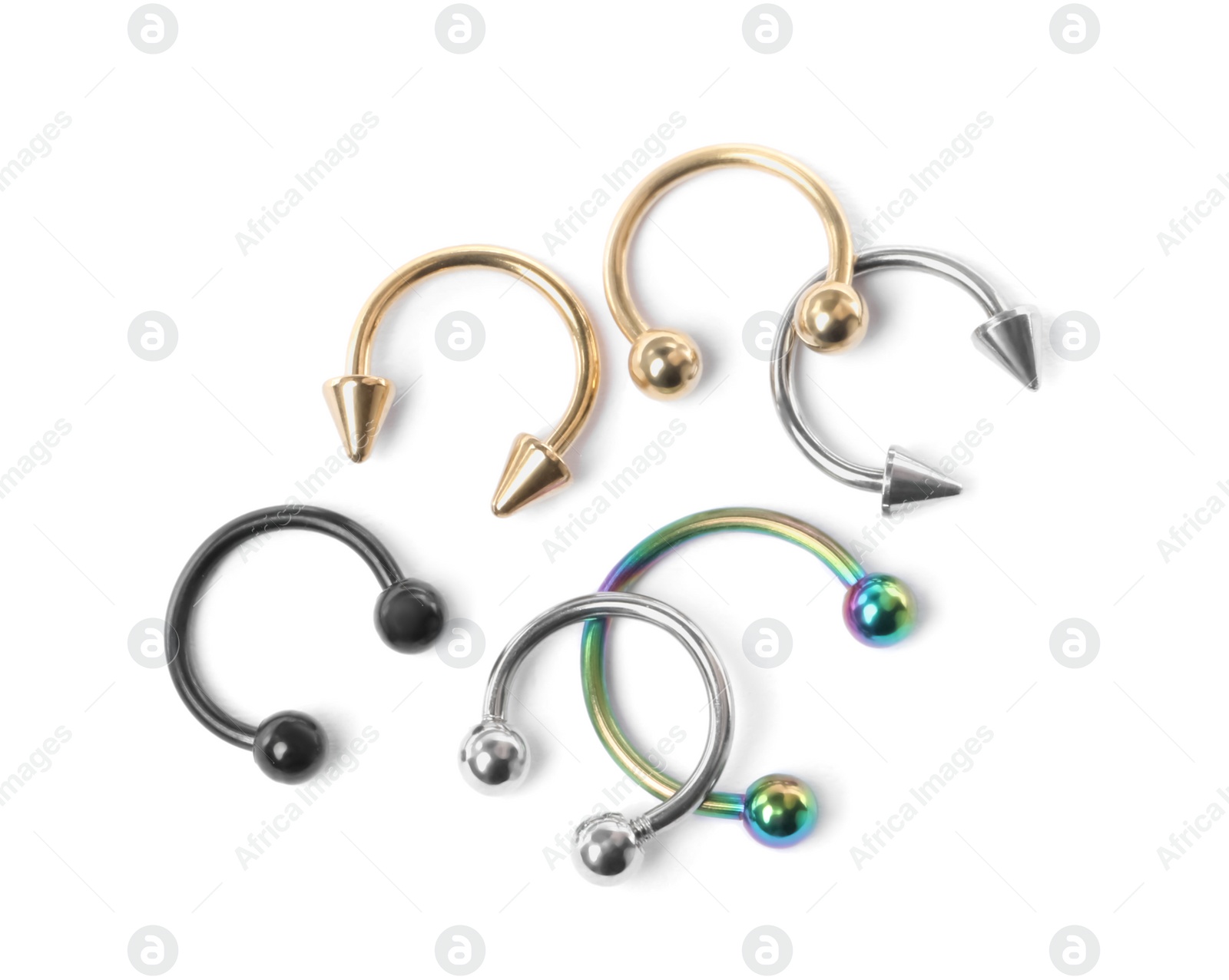 Photo of Piercing jewelry. Many different circular barbells on white background, top view