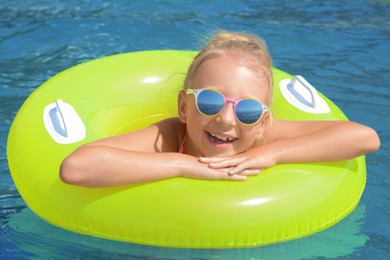 Photo of Little girl with inflatable ring in sea on sunny day