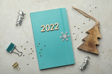 Photo of Turquoise planner, stationery and Christmas decor on light table, flat lay. Planning for 2022 New Year