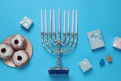Photo of Flat lay composition with Hanukkah menorah and donuts on light blue background