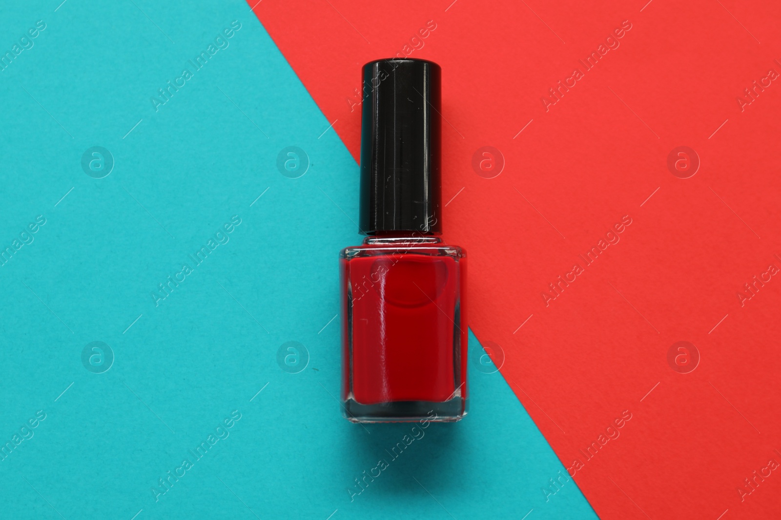 Photo of Nail polish on color background, top view