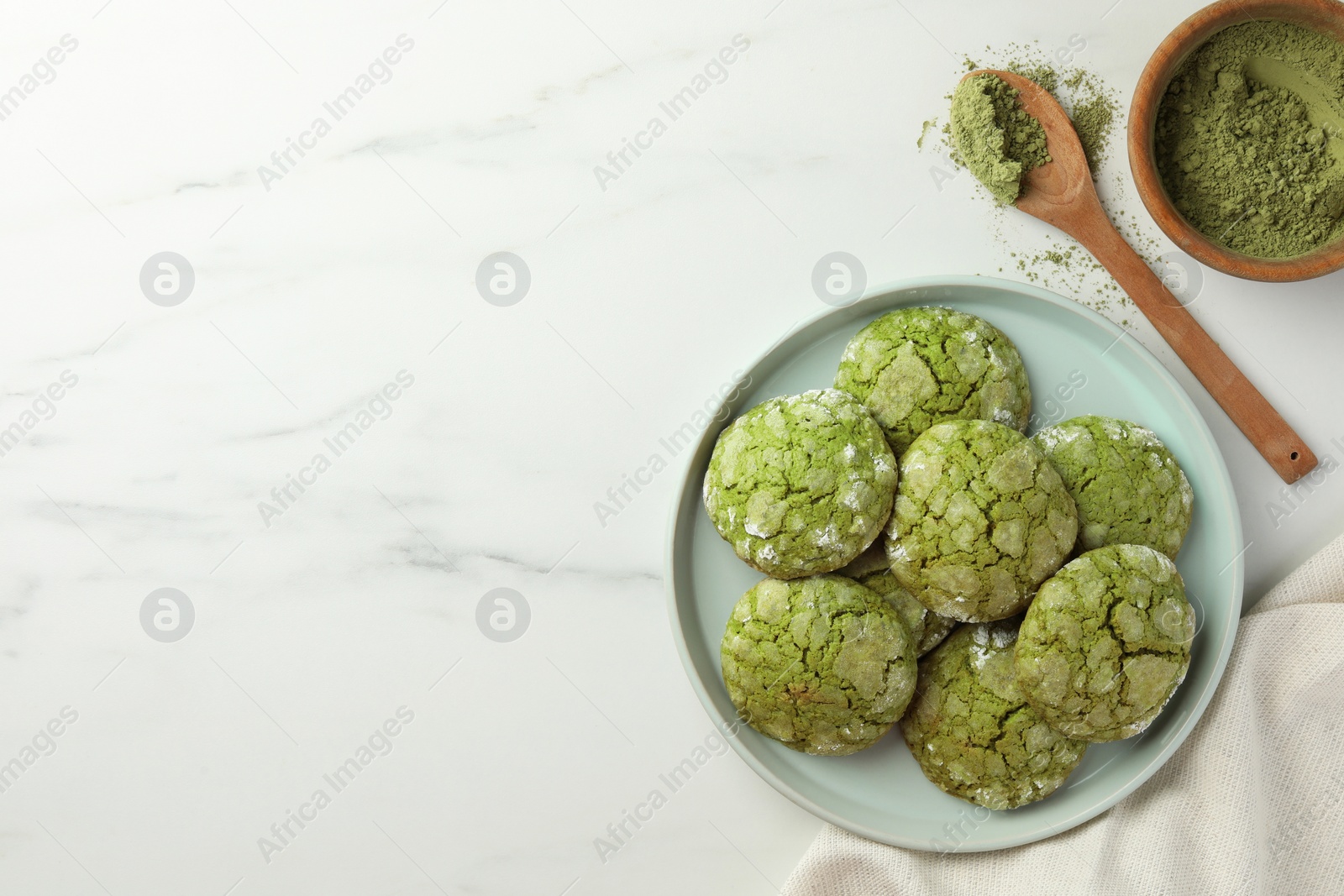 Photo of Plate with tasty matcha cookies and powder on white marble table, flat lay. Space for text