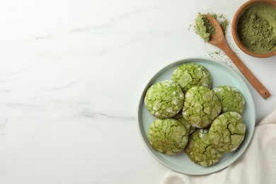 Plate with tasty matcha cookies and powder on white marble table, flat lay. Space for text