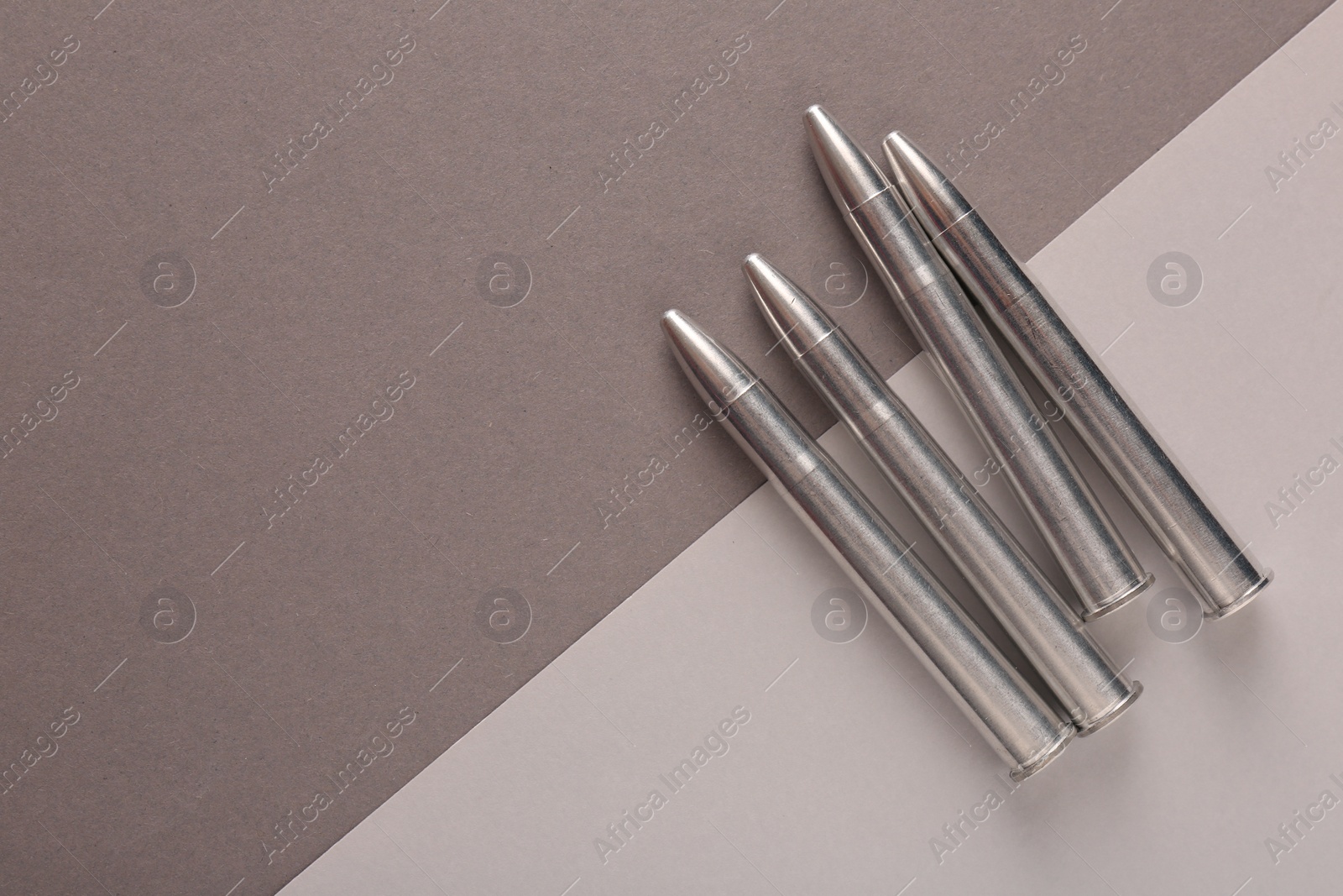 Photo of Many metal bullets on color background, flat lay. Space for text