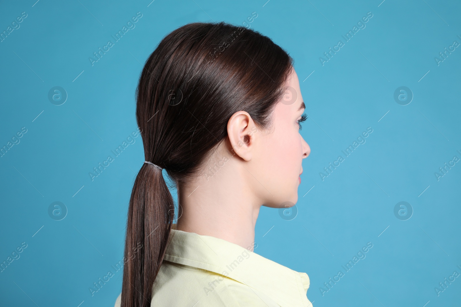 Photo of Side view of young woman on light blue background