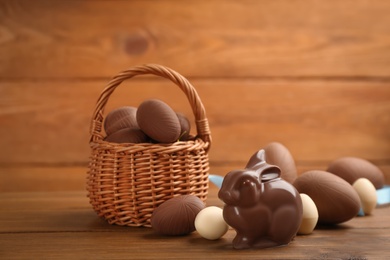 Photo of Chocolate Easter bunny and eggs on wooden table