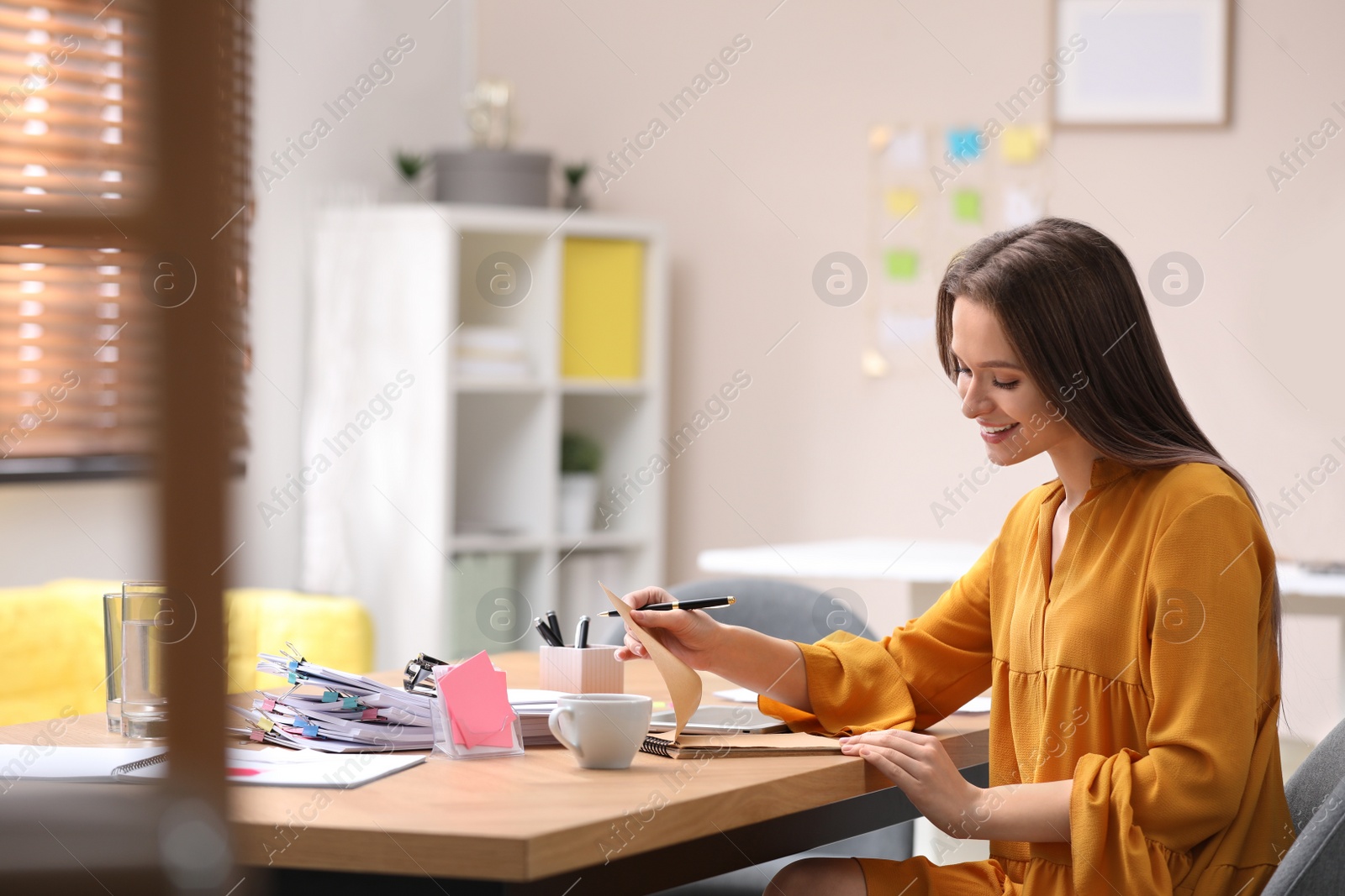 Photo of Young journalist at workplace in light office