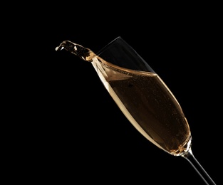 Glass of fizzy champagne on black background, closeup