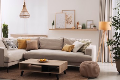 Stylish living room interior with comfortable grey sofa and coffee table