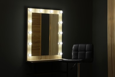 Photo of Beautiful mirror with light bulbs and chair in makeup room