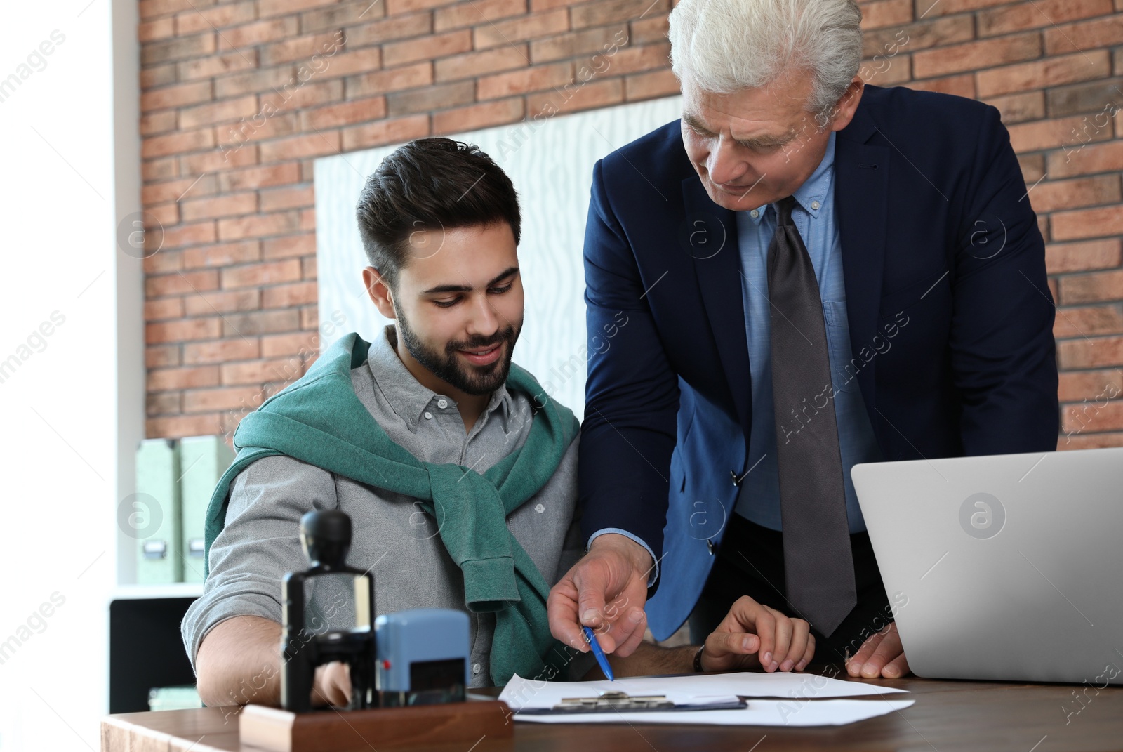 Photo of Senior notary working with client in office