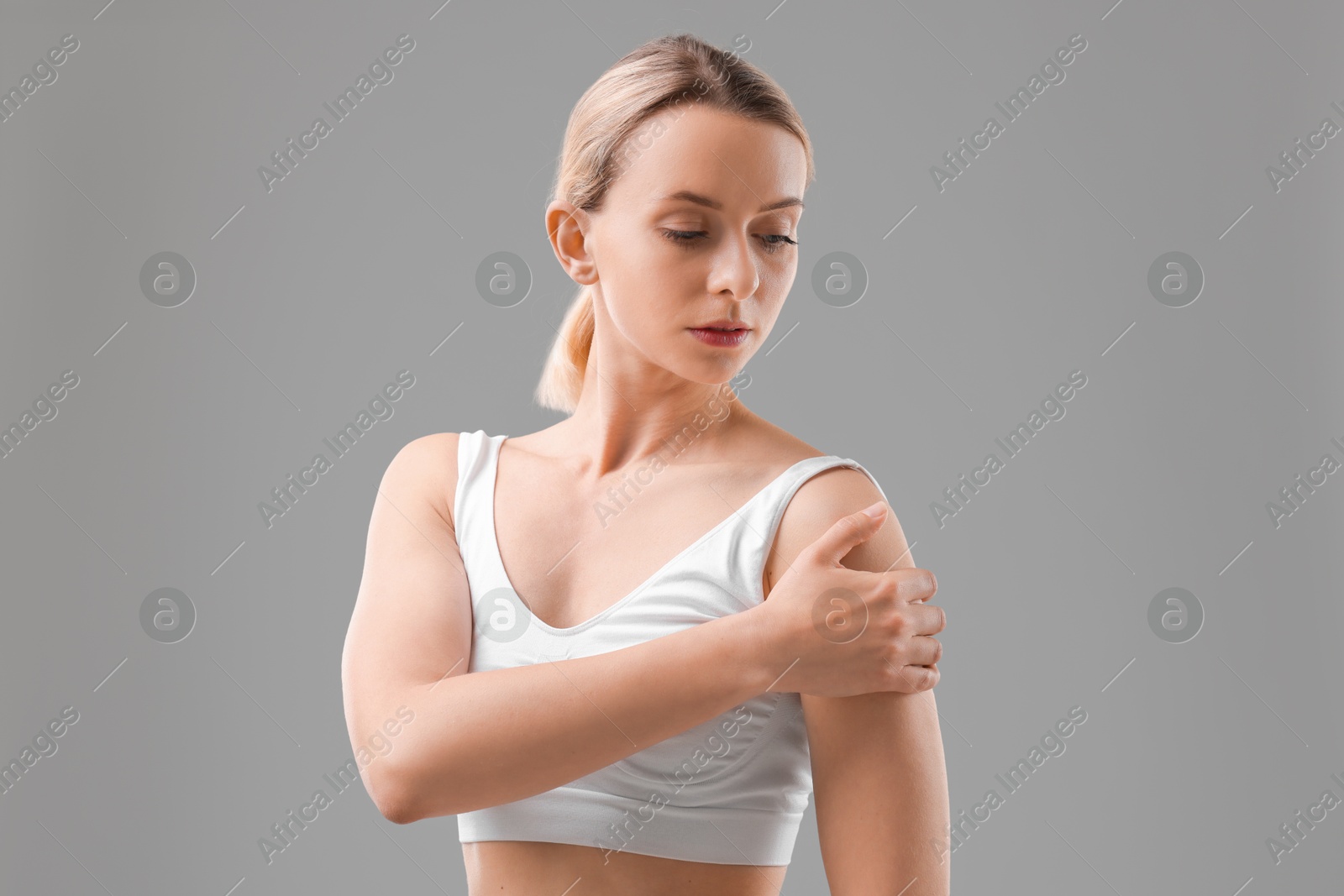 Photo of Woman with sporty body on grey background