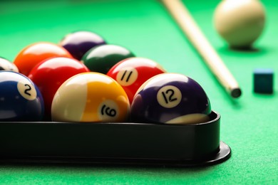 Billiard balls in triangle rack on green table, closeup