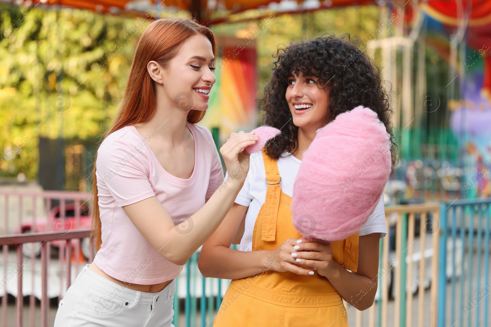 Photo of Happy friends with cotton candy spending time together at funfair