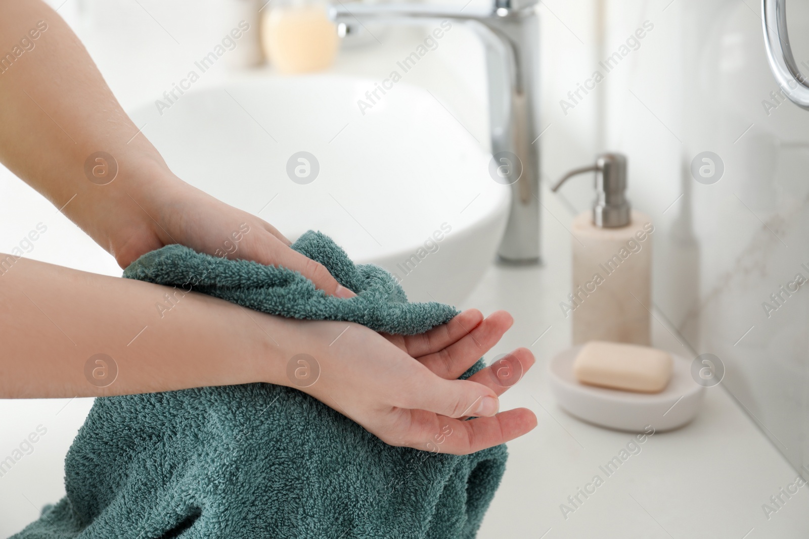 Photo of Woman wiping hands with towel in bathroom, closeup