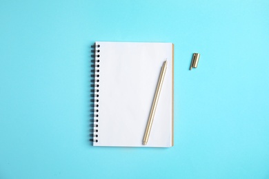 Photo of Empty notebook and pen on color background, top view