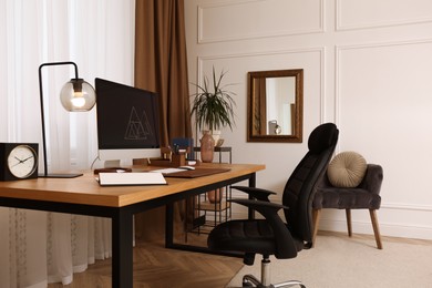 Stylish room interior with comfortable workplace near window