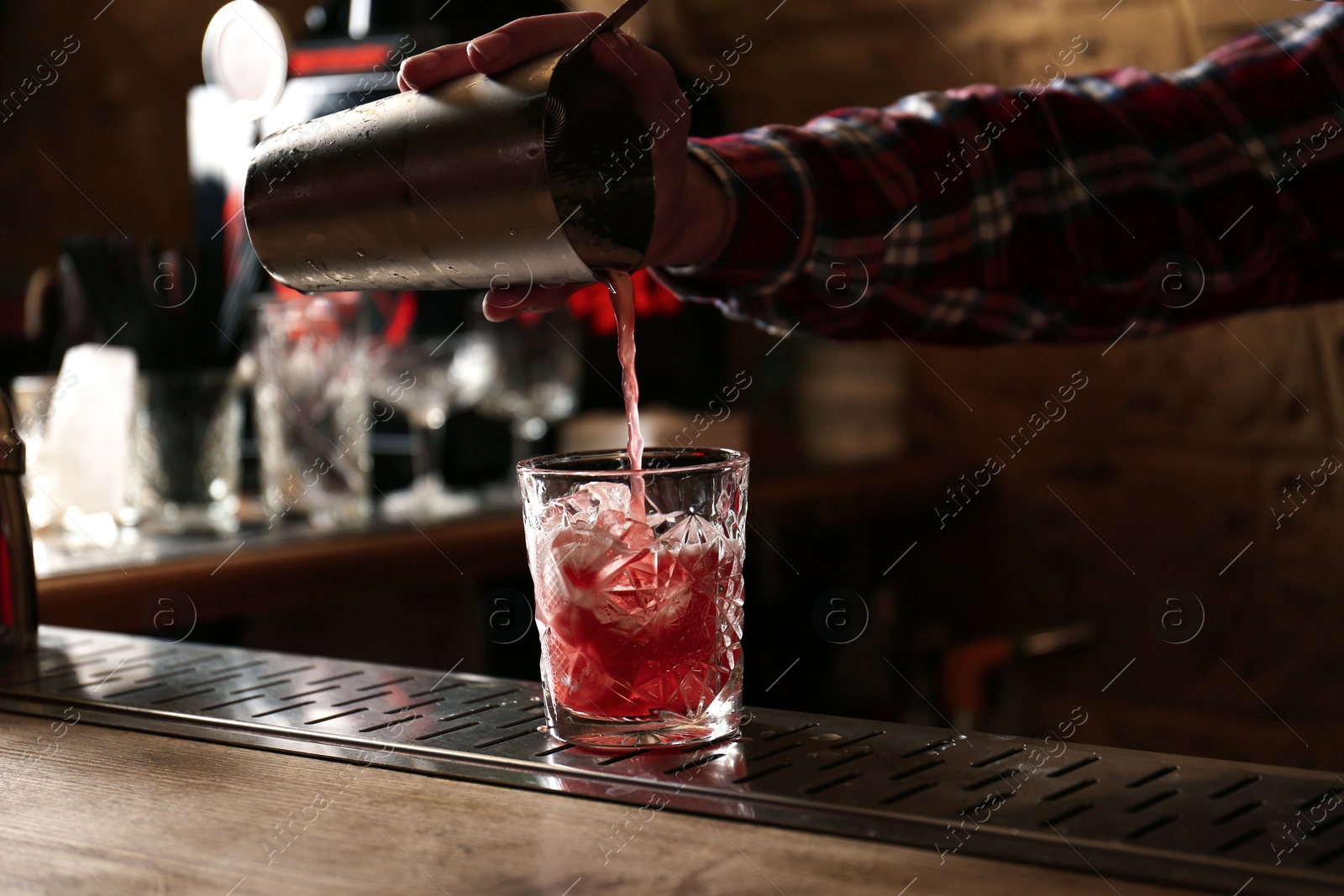 Photo of Bartender preparing fresh alcoholic cocktail at bar counter, closeup