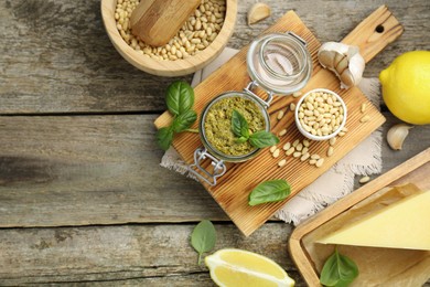 Photo of Delicious pesto sauce and ingredients on wooden table, flat lay. Space for text